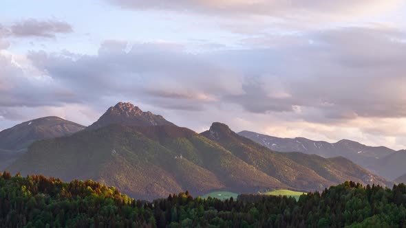 Time Lapse Motion of Fast Clouds Over Misty Alps Mountain Peak in Sunny Spring Nature at Sunset