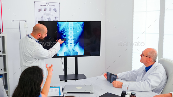 Expert doctor holding medical training pointing on digital x-ray