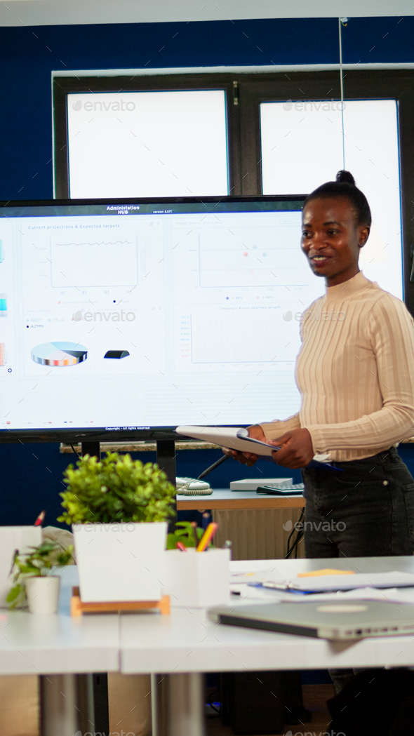 Black analyst using digital interactive whiteboard for presentation