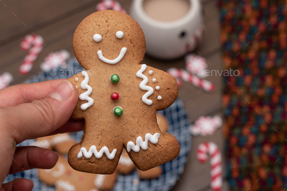 Woman hand holding a gingerbread man cookie - Stock Photo - Images