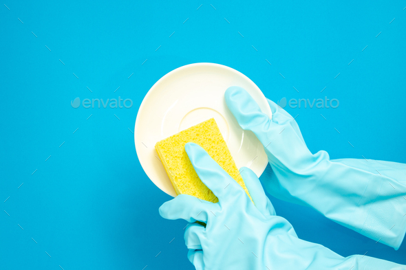 Dishwashing concept, Hands in rubber gloves to holding yellow sponge and wash the dishes