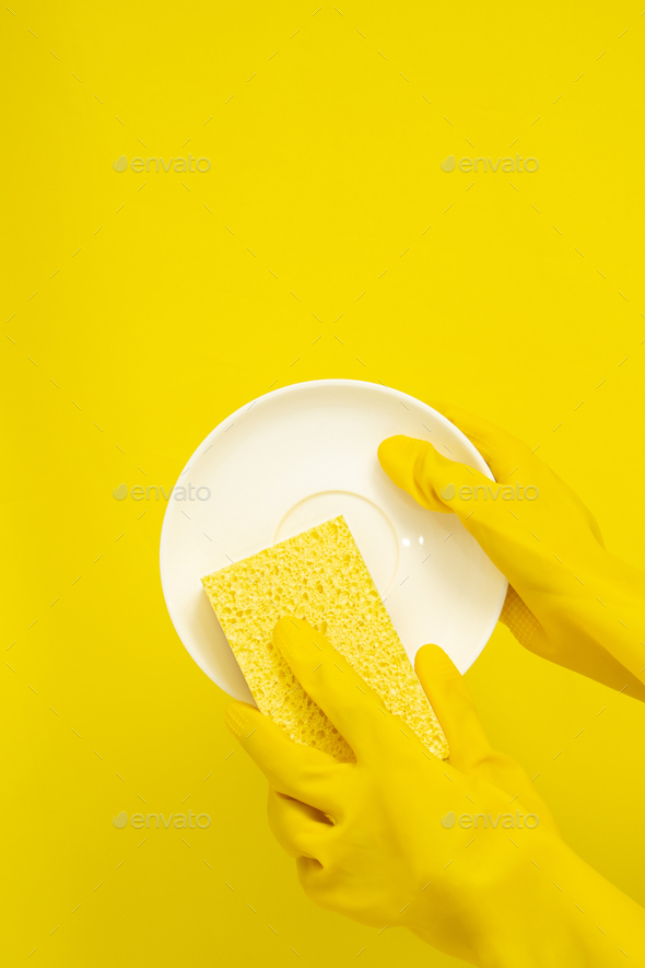 Dishwashing concept, Hands in rubber gloves to holding yellow sponge and wash the dishes