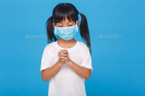 Asian girl wearing mask for protect pm2.5 and coronavirus Covid-19.Stay at home praying to GOD.