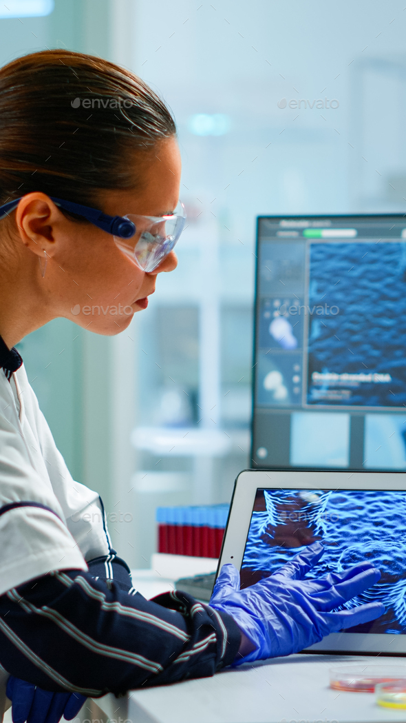 Scientist using digital tablet analysing virus evolution