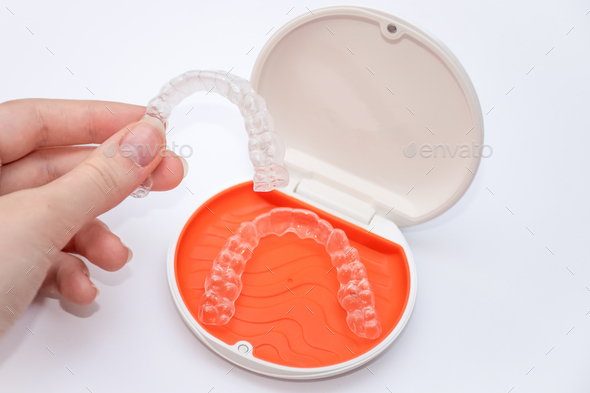 Transparent aligners retainers in a storage case. Invisible braces.