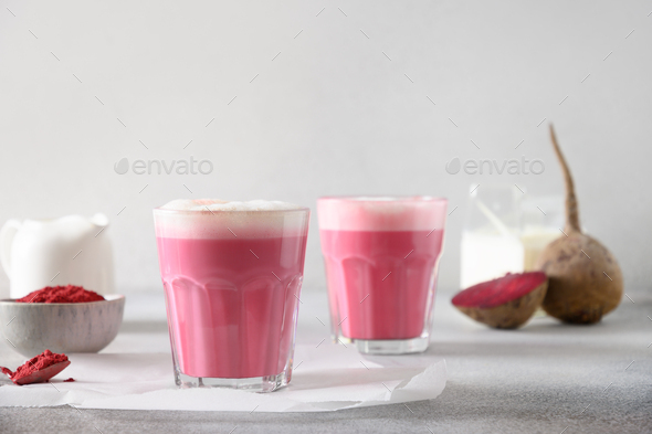 Beetroot latte or pink moon milk latte in cup on gray background. Great warming drink.