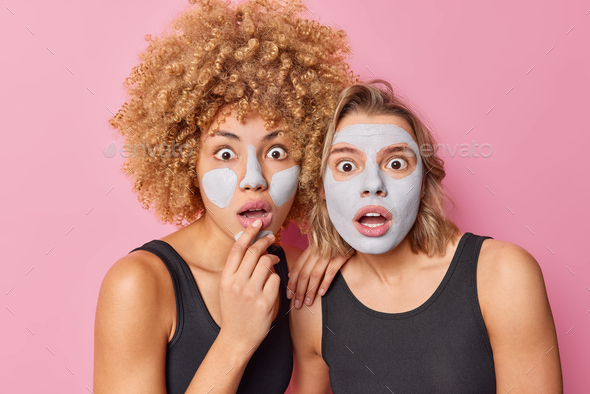 Photo of scared young women stare bugged eyes apply clay mask on face to reduce fine lines wears cas