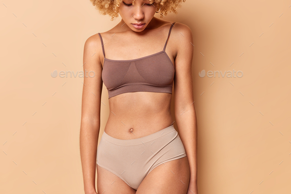 Foto Stock Tanned woman in great shape, perfect body shape. Parts of a  female body in underwear, studio shot.