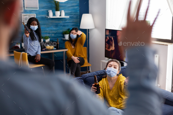 Man coming at party with friends wearing face mask