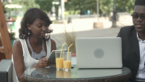 Afro-american Business Man and Woman Working Together in Modern Cafe, Having Phone Calls, Using alt