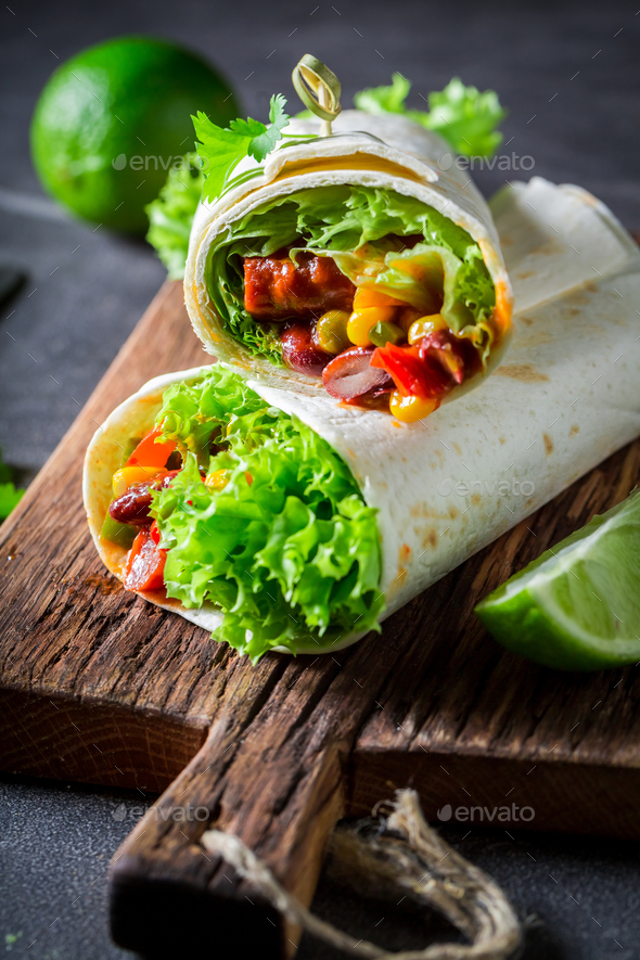 Spicy and hot burrito with red salsa and vegetables.