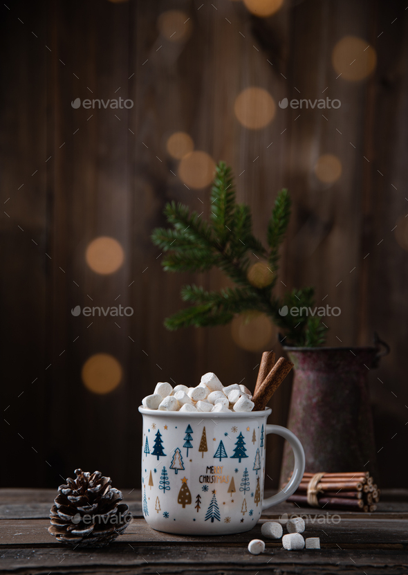 Christmas cup of cacao and marshmallow with cinnamon on an old brown wooden table with bokeh