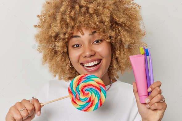 Headshot of positive woman with curly hair holds big multicolored ...