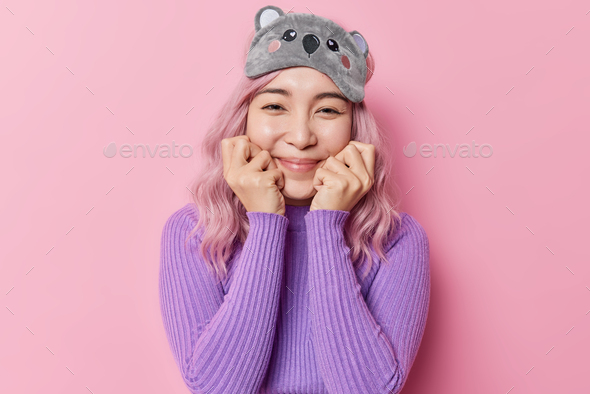 Horizontal Shot Of Happy Rosy Haired Asian Woman Keeps Hands Under Chin Has Gentle Expression