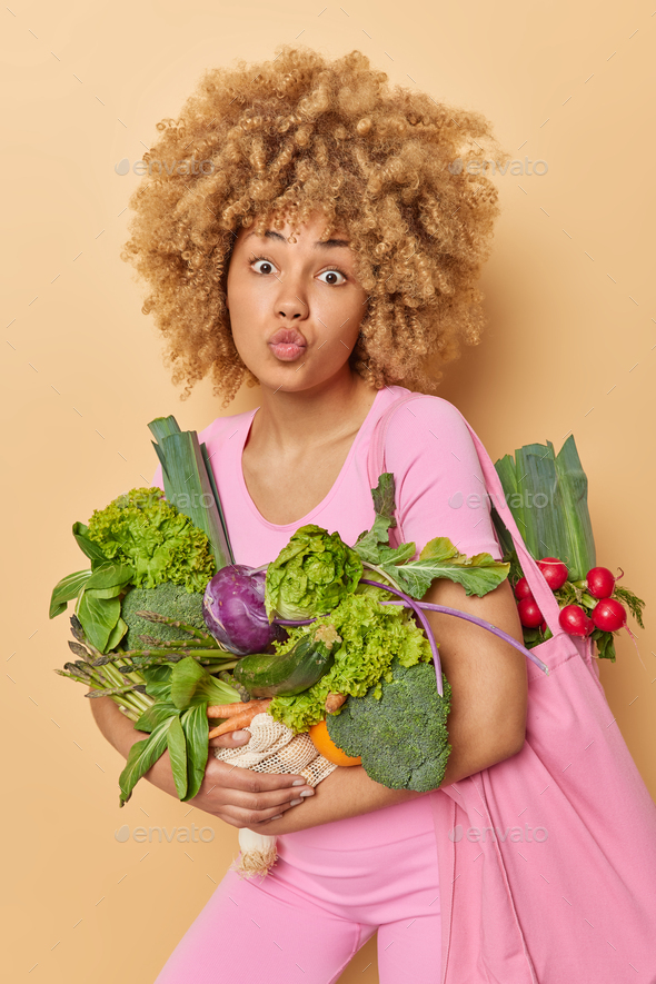 Healthy food clean eating and zero waste concept. Surprised young woman with curly bushy hair