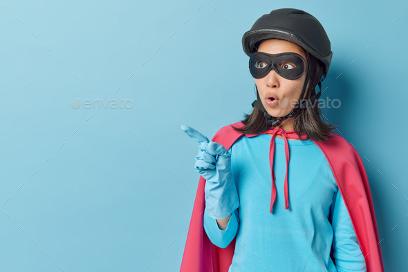 Surprised woman wears superhero costume has unusual abilities special strength and courage points aw