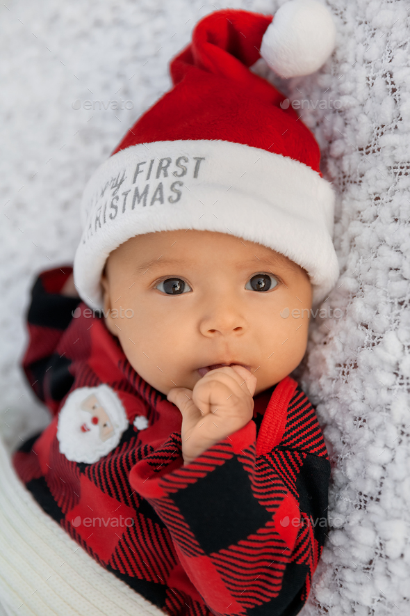 Newborn baby dressed in cozy Santa outfit, closeup portrait of infant girl on soft white background - Stock Photo - Images
