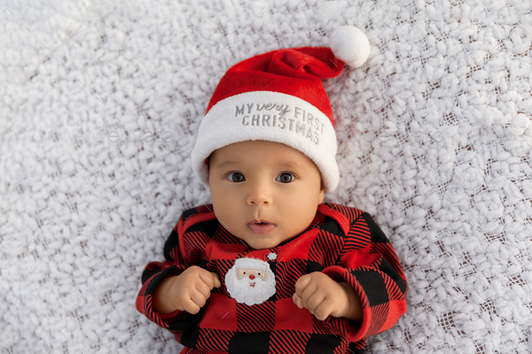 Portrait of infant baby girl dressed in Christmas outfiit looking at camera - Stock Photo - Images