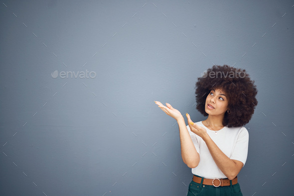 Afro woman, showing hands and advertising space on grey studio background for marketing mockup, cre