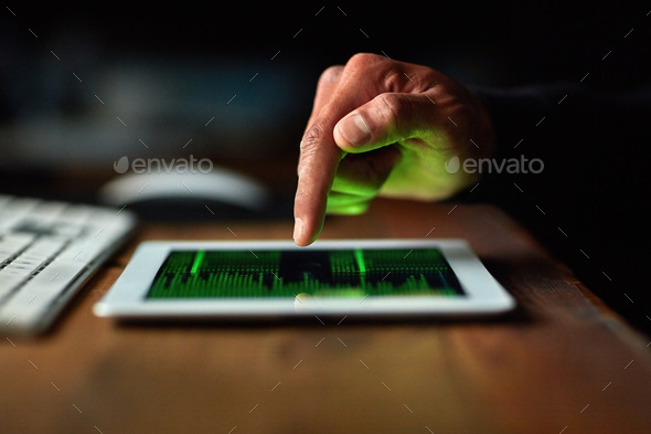 Cropped shot of an unidentifiable hacker cracking a computer code in the dark