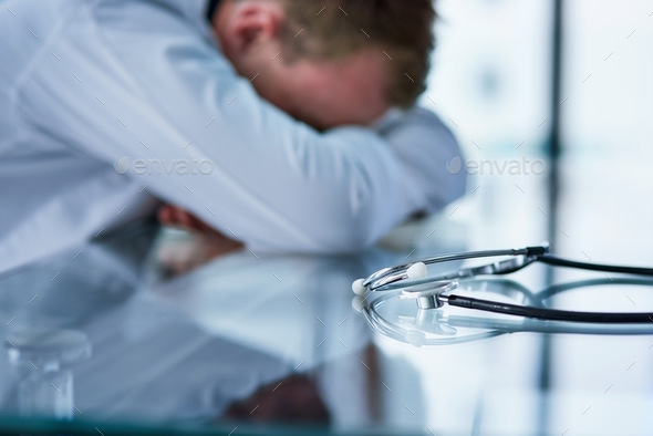 Not even doctors are exempt from burnout. Shot of a doctor experiencing stress at work. - Stock Photo - Images