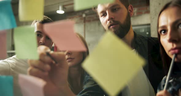 Team Putting Stickers on Glass Wall Brainstorming