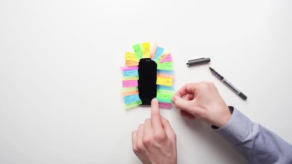 Timelapse of a man sticking post it notes to a phone