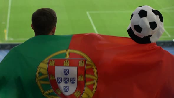 Football Fans With Portuguese Flag Jumping and Watching Game at Stadium, Slow-Mo alt