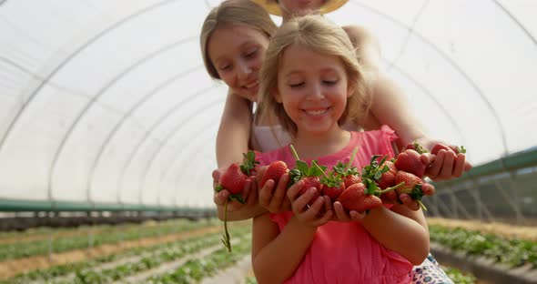 Girls holding strawberries in the farm 4k alt
