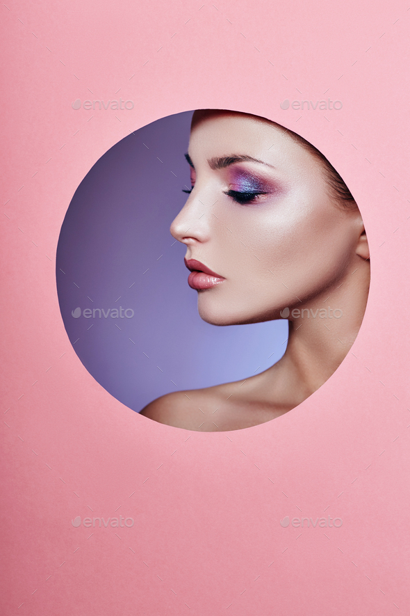 Beauty makeup cosmetics nature fashion woman in a round hole circle in pink paper