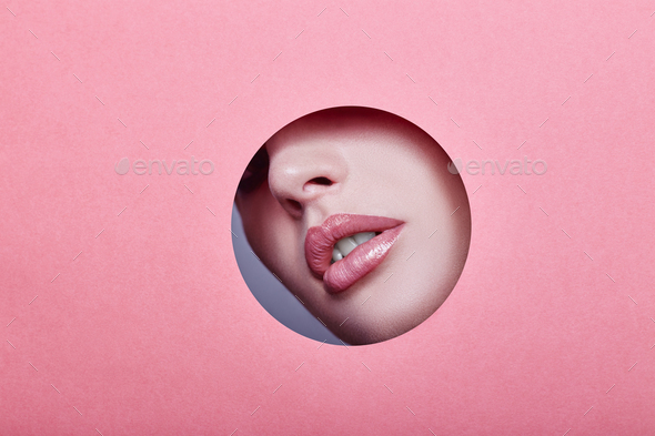 Woman looking in the hole, bright beautiful makeup, big eyes and lips, bright lipstick