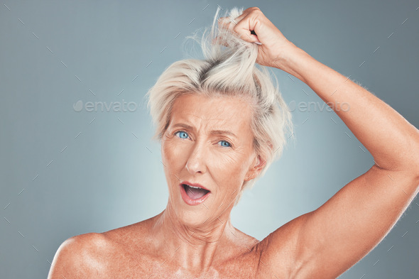 Senior, woman and hair with wow face in studio for cosmetics, beauty and wellness against blue back