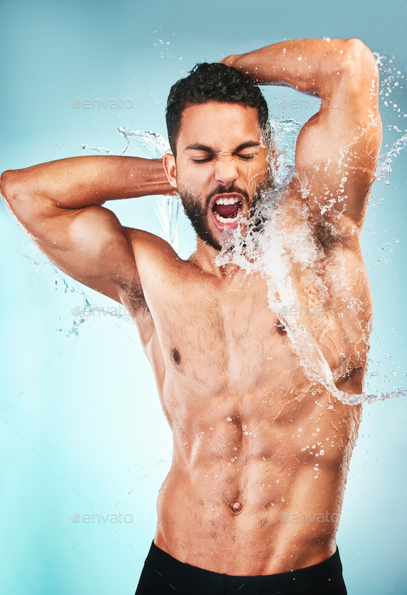Body, water and shower with a muscle man in studio on a splash blue