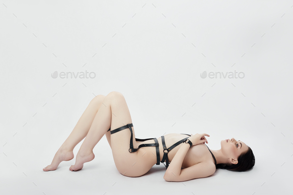 Beautiful Nude woman in BDSM lingerie on white background, erotic