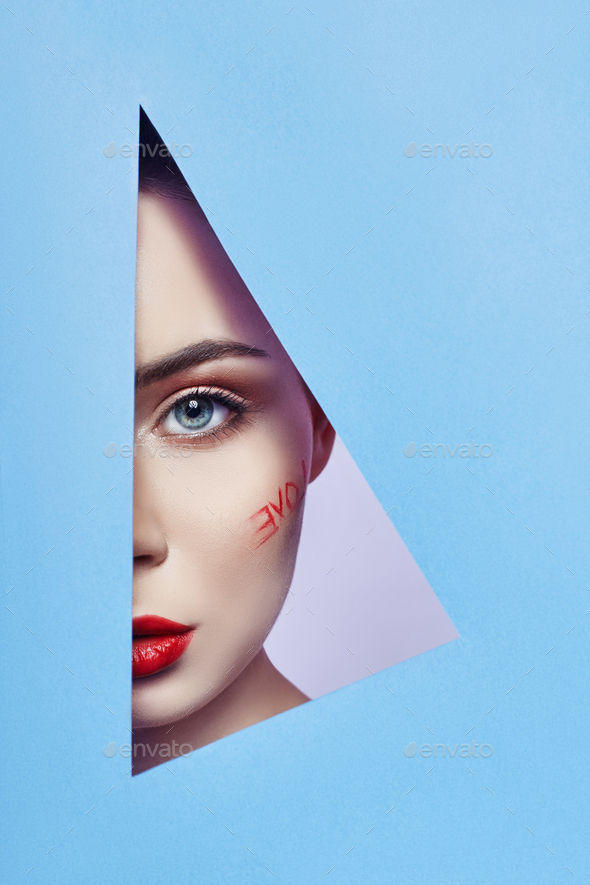 Woman looking in blue triangle hole, bright beautiful makeup love word, big eyes