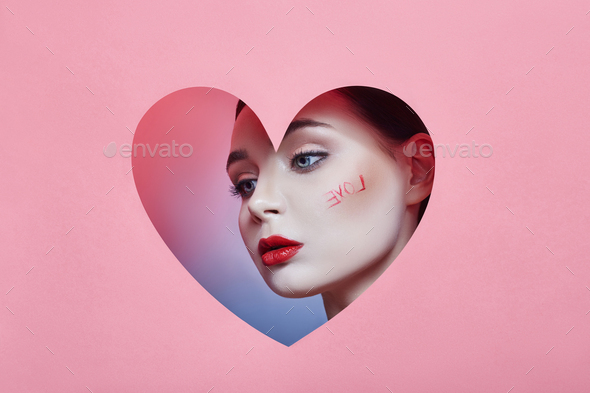 Woman looking in the heart hole, bright beautiful makeup, big eyes and lips, bright lip