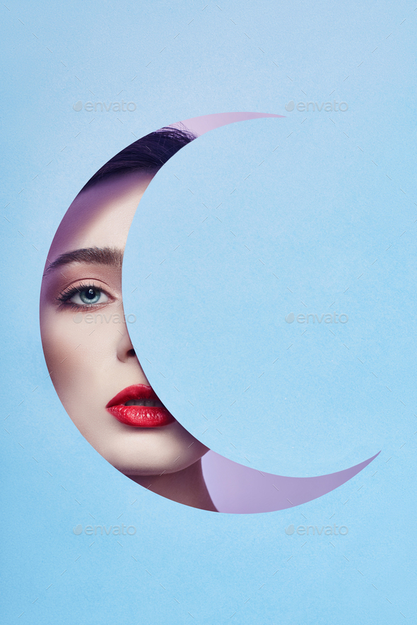 Woman looking in blue moon month hole, bright beautiful makeup, big eyes and lips