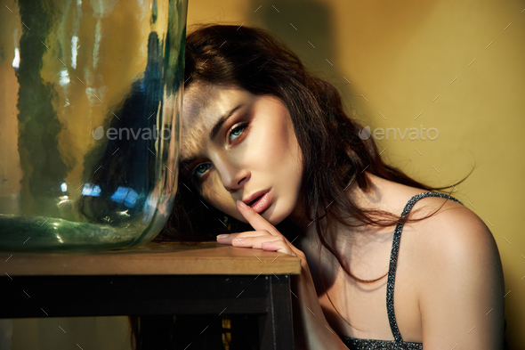 Art Portrait of a makeup woman with reflection of sunlight on her face, refraction of light