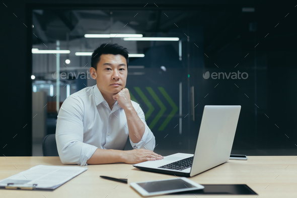 Portrait of an Asian man, businessman, company founder, office worker sitting in the office