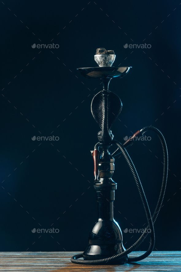 black hookah stem and hose on wooden surface on black Stock Photo by