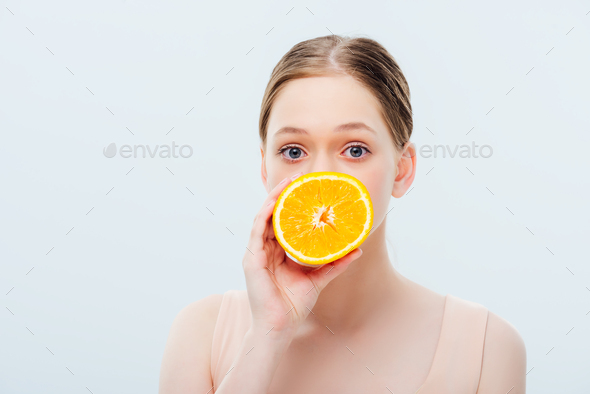 teenage girl with obscure face holding ripe orange half isolated on grey