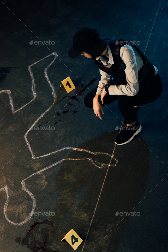 overhead view of investigator near chalk outline and evidence markers at crime scene