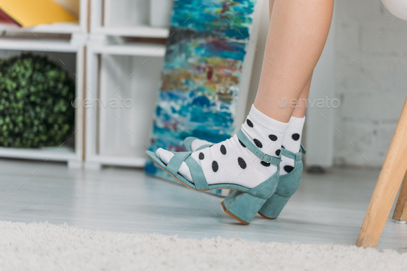cropped view of trendy girl in dotted socks and sandals on heels