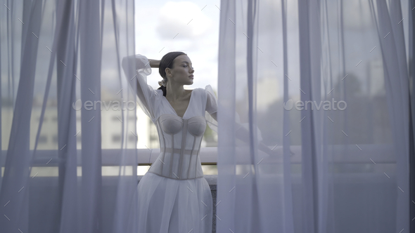A beautiful caucasian girl in a long white dress poses dramatically in a  Gothic style for an editorial photo shoot. The theme is Winter Fairytale  Stock Photo - Alamy