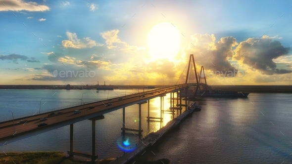 Cars driving on a bridge with the beautiful sunset in the background in Charleston, South Carolina