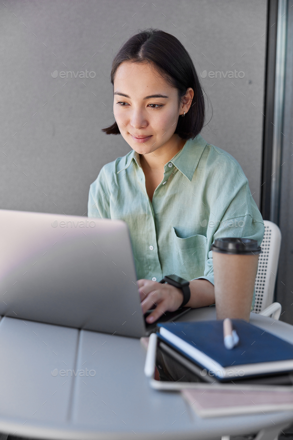 Female IT professional does freelance job on laptop computer searches content publication in social