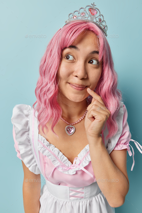 Thoughtful Pink Haired Asian Housewife Keeps Index Finger Near Corner