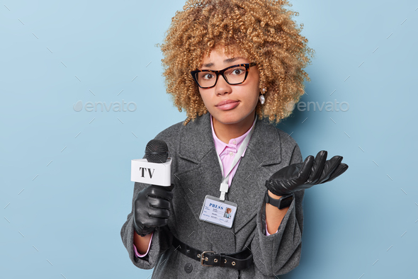 Social media press and news concept. Confused female correspondent holds reporter microphone wears e