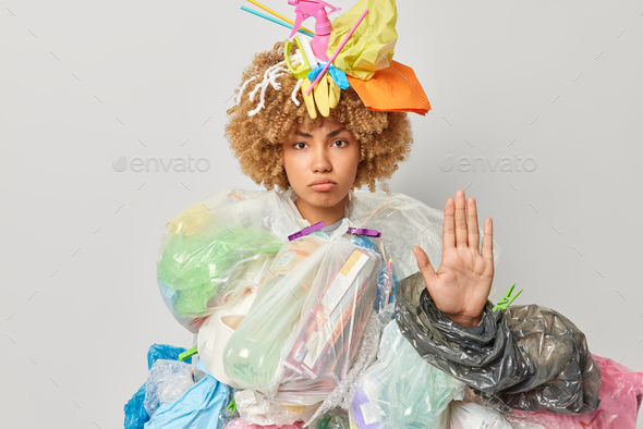 Photo of serious woman volunteer makes stop gesture keeps palm raised asks to stop environmental pol