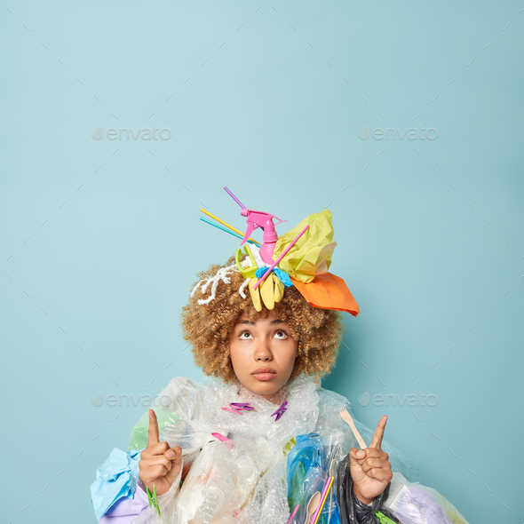 Serious self confident woman volunteer collects plastic garbage for recycling points index fingers a